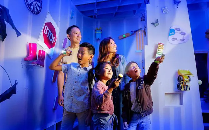 Kids using flashlights to explore interactive exhibits at SparkLab, Queensland Museum.