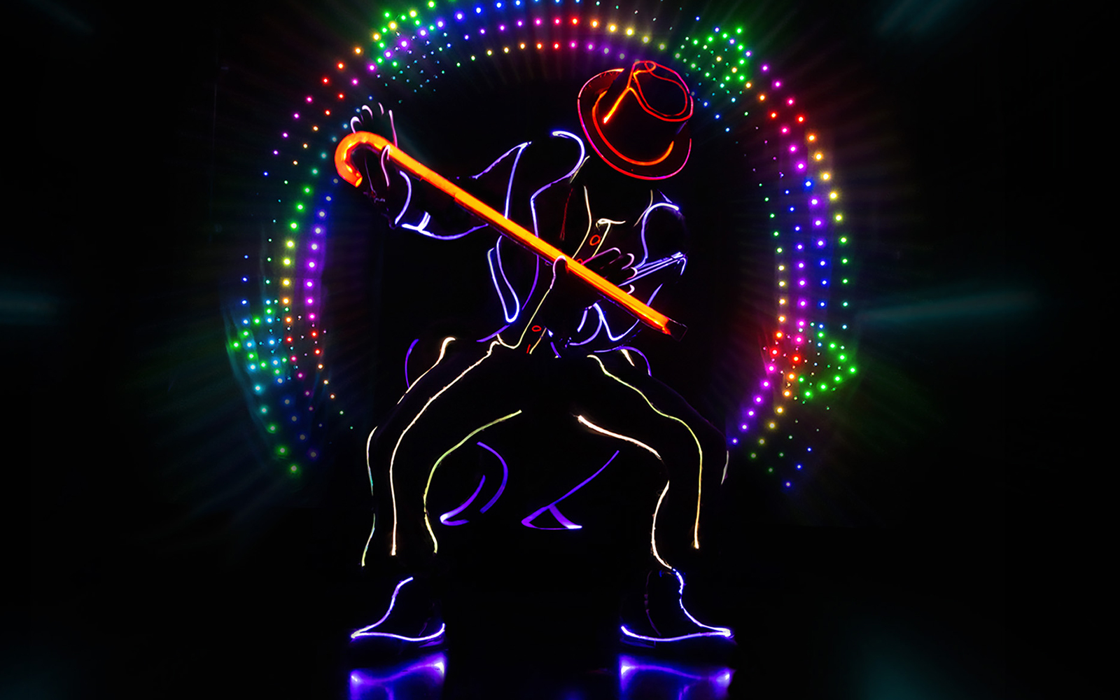 Performer in neon lights with cane at iLuminate show.