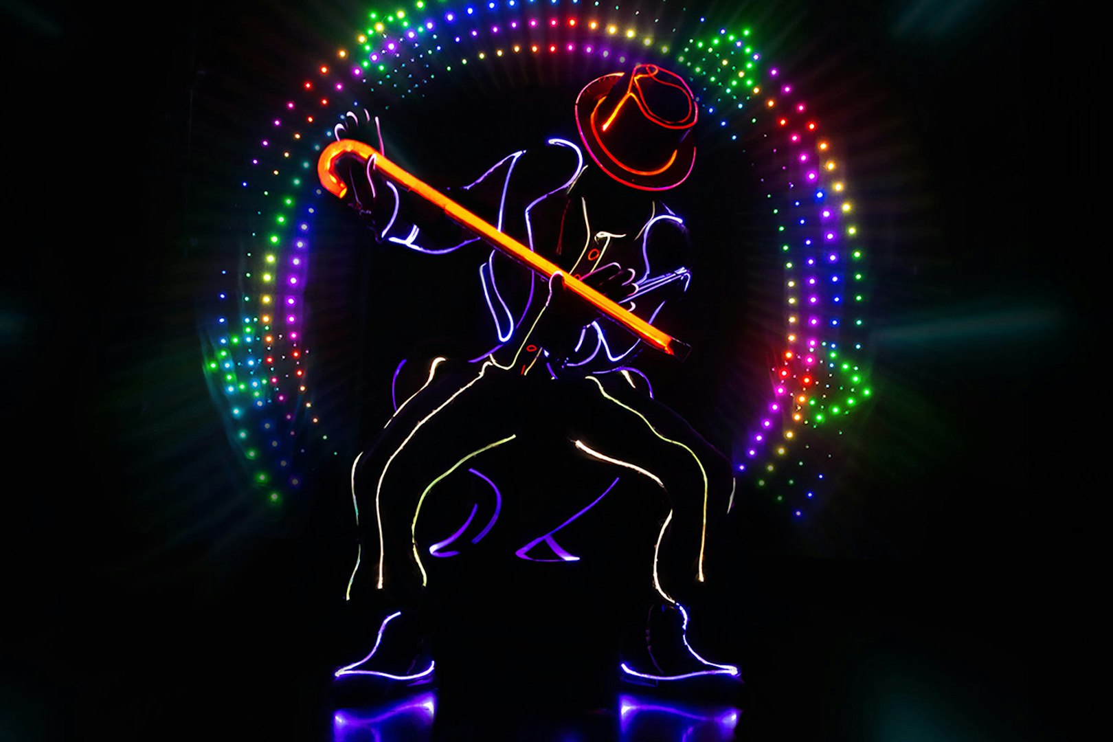 Performer in neon lights with cane at iLuminate show.