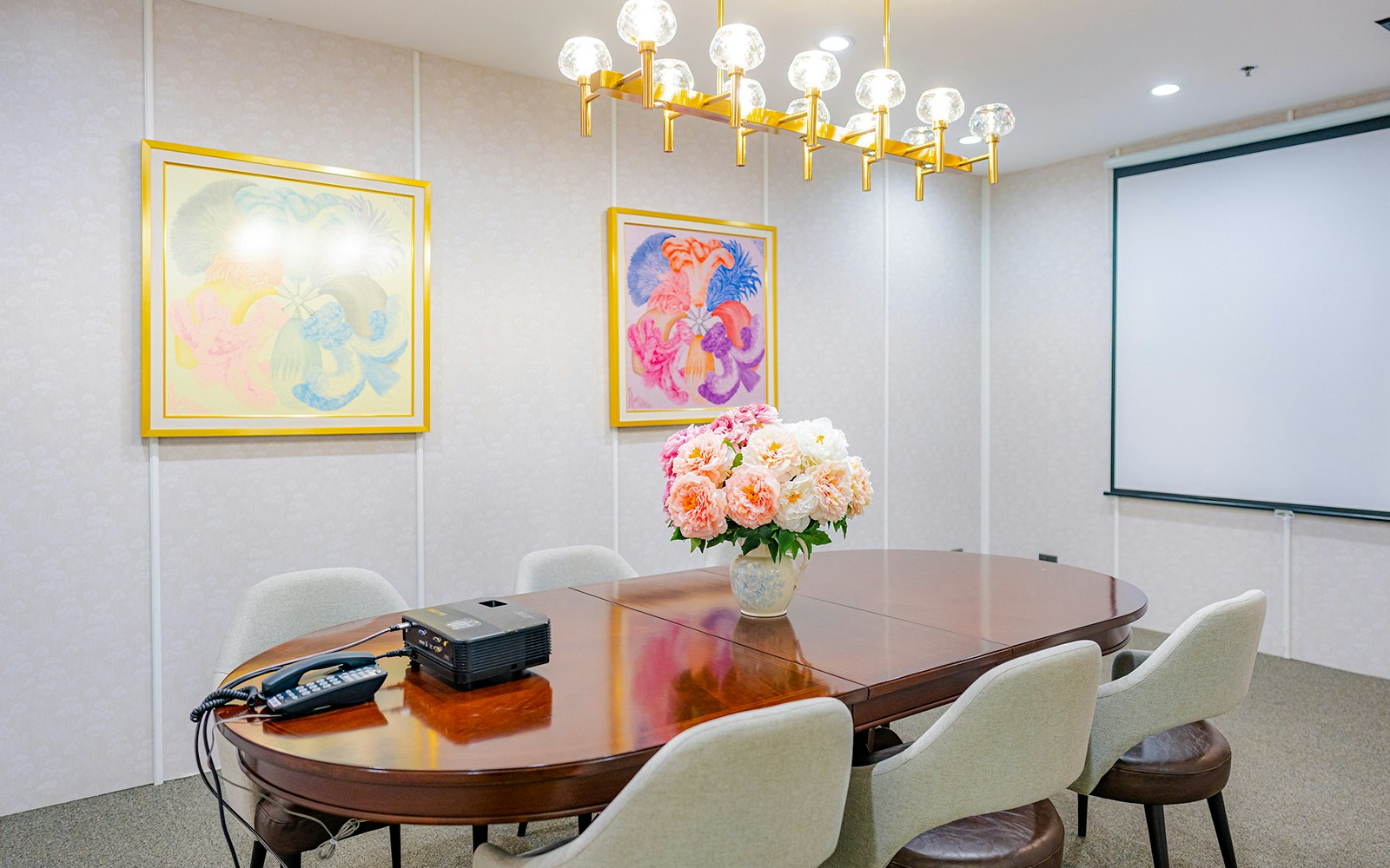 Meeting room with floral centerpiece and projector at Coral Finest Business Class Lounge, Bangkok airport.