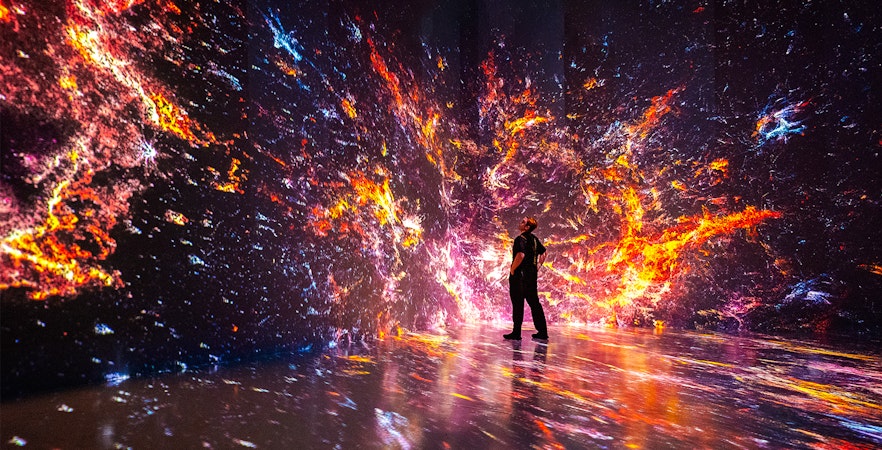 Immersive digital art installation at ARTECHOUSE, New York with vibrant cosmic visuals.