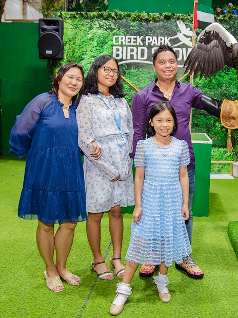 Tourists at Creek Park Bird Show posing with an eagle on a handler's glove.
