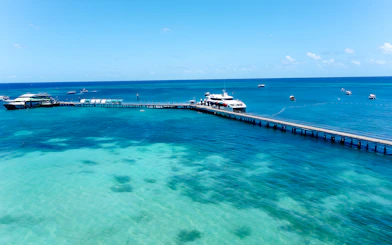 Docked boat at Green Island pier, Cairns, with clear turquoise waters and distant boats.