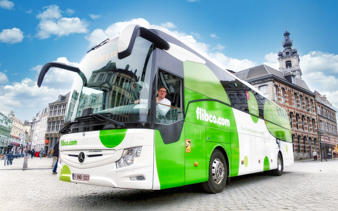 Flibco airport transfer bus in a European city square.