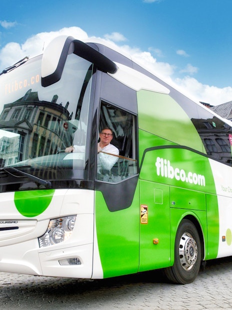 Flibco airport transfer bus in a European city square.