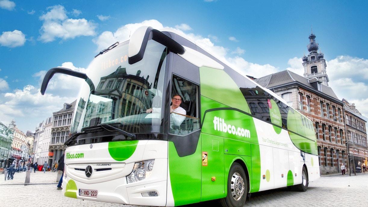 Flibco airport transfer bus in a European city square.