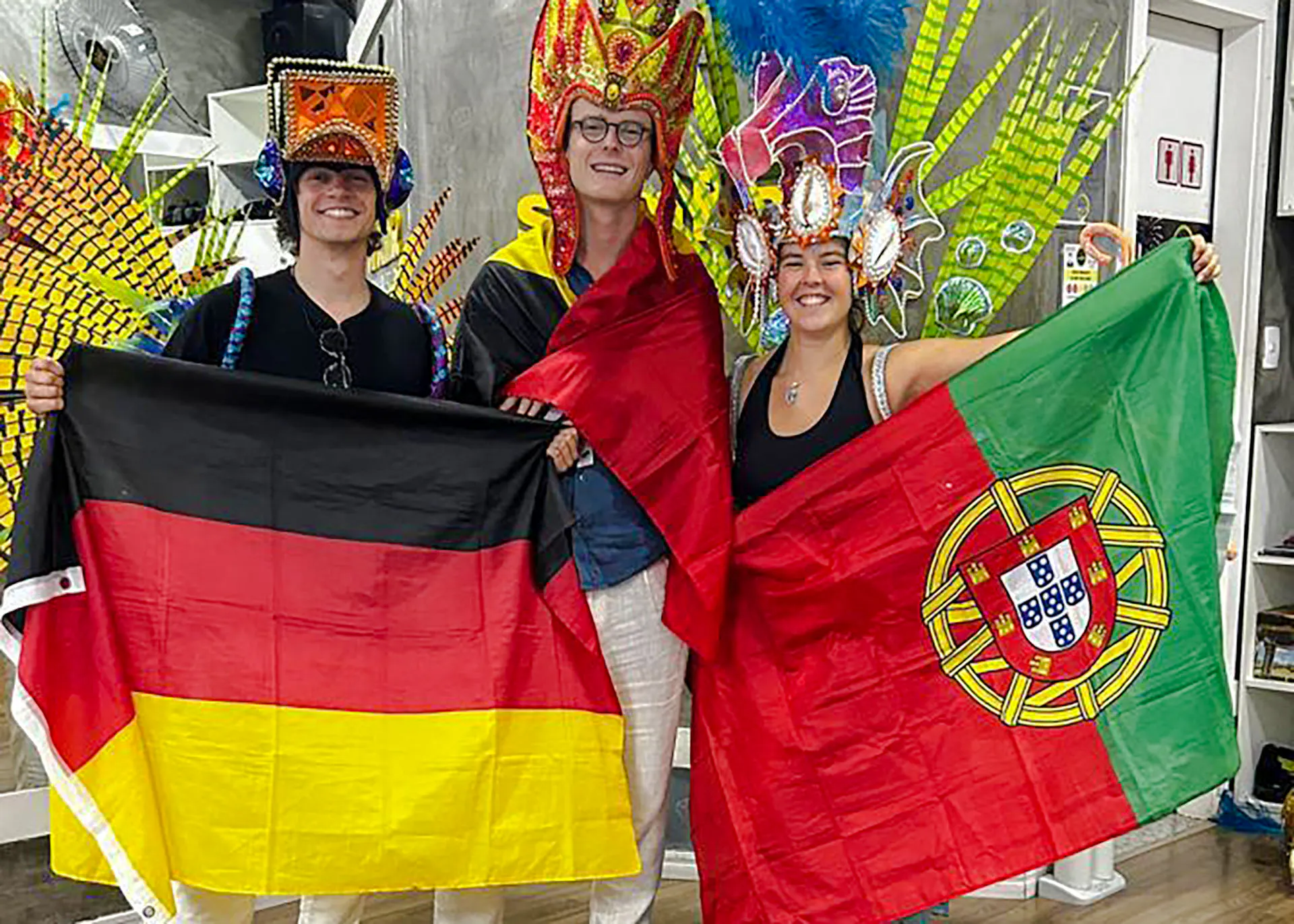 Participants in colorful costumes holding flags at Samba class, Rio de Janeiro.