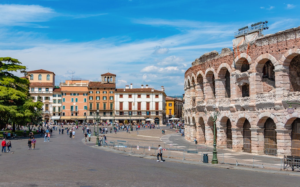 Verona Arena with surrounding plaza and colorful buildings in Verona, Italy.