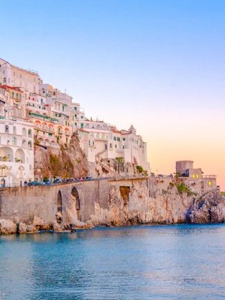 Cliffside buildings overlooking the sea at sunset in Amalfi, Italy.