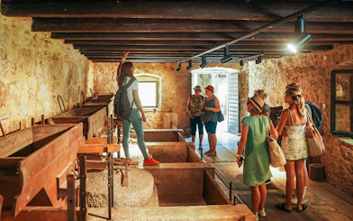 Visitors exploring a historic stone building in Krka National Park.