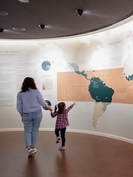 Mother and child exploring a cacao exhibit at a Porto museum.