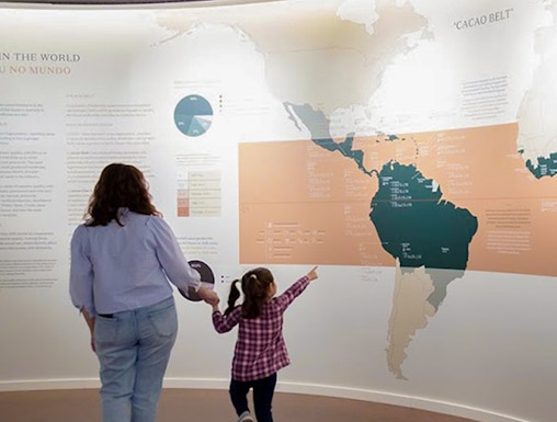 Mother and child exploring a cacao exhibit at a Porto museum.