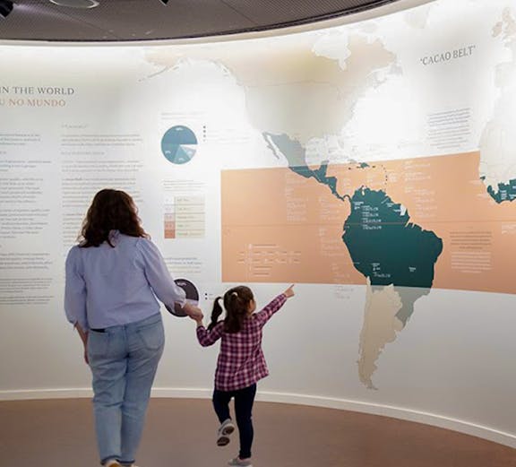 Mother and child exploring a cacao exhibit at a Porto museum.