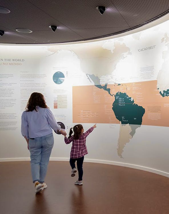 Mother and child exploring a cacao exhibit at a Porto museum.