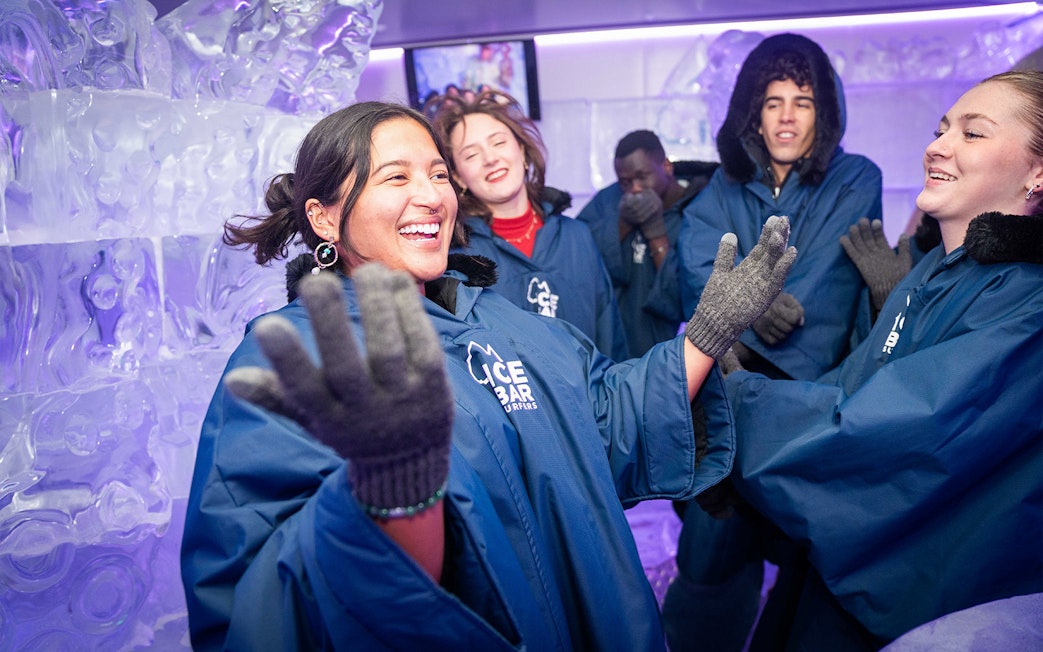 Visitors enjoying IceBar Surfers Paradise in winter coats and gloves.