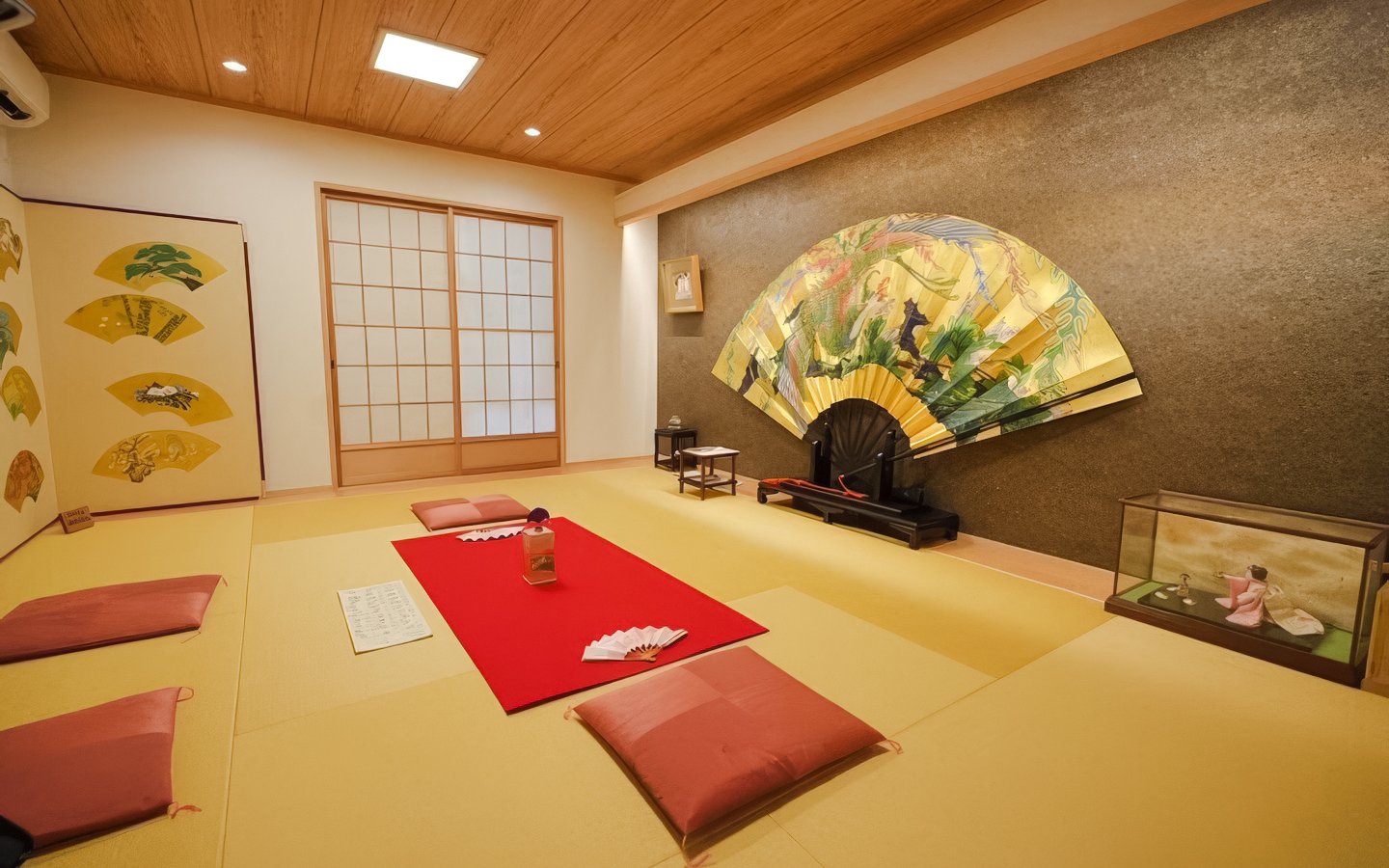 Geisha meeting room with tatami mats, decorative fans, and traditional seating in Japan.