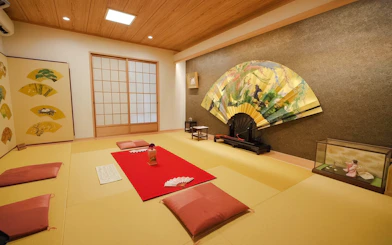 Geisha meeting room with tatami mats, decorative fans, and traditional seating in Japan.