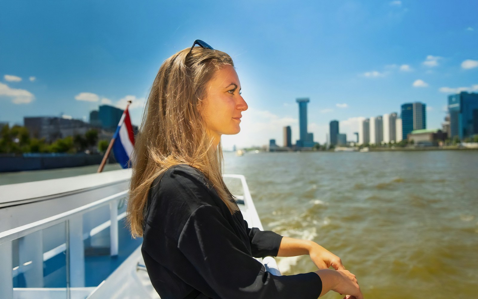 Guests enjoying Rotterdam Harbour Cruise on historic ship with city skyline in background.