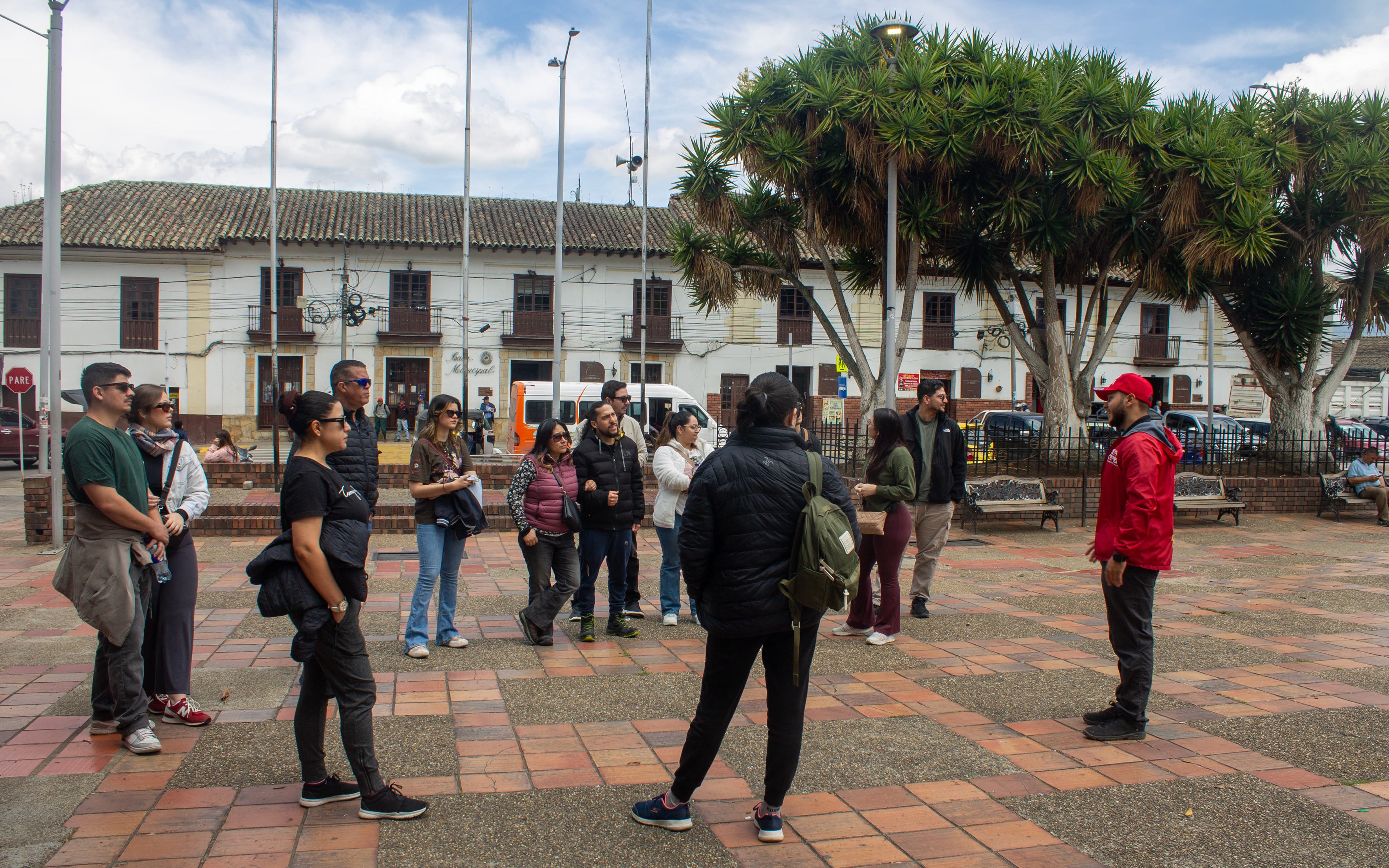 Tourists receiving a briefing from a guide in a historic town square.