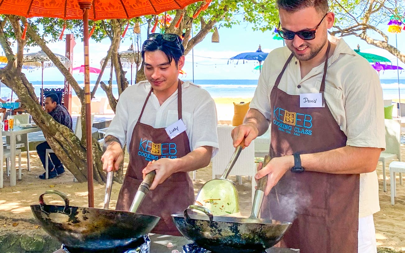 Participants cooking at Kekeb Balinese Cooking Class, Nusa Dua beach setting.
