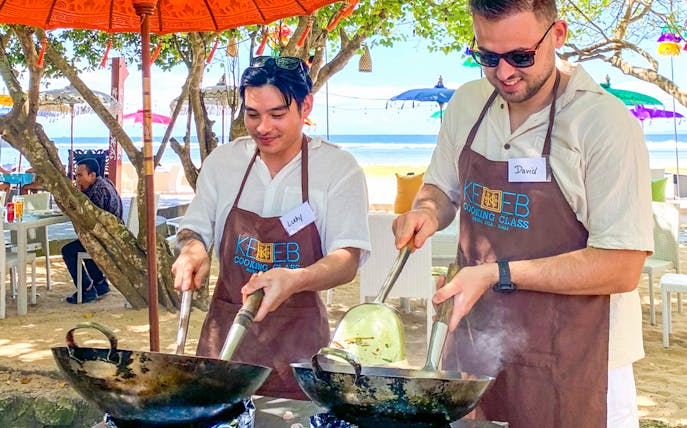 Participants cooking at Kekeb Balinese Cooking Class, Nusa Dua beach setting.