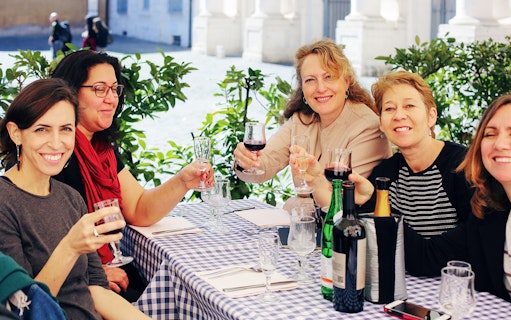 Friends enjoying wine at an outdoor cafe in Rome.