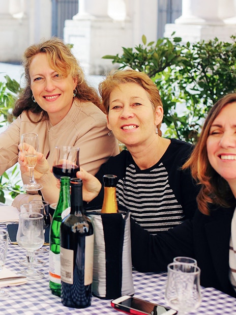 Friends enjoying wine at an outdoor cafe in Rome.