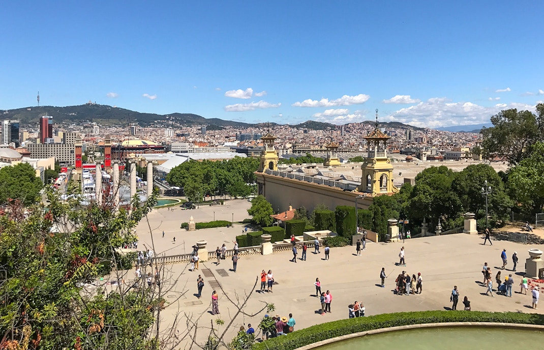 Cable car ascending Parc de Montjuic, Barcelona, with cityscape and Mediterranean Sea in the background.