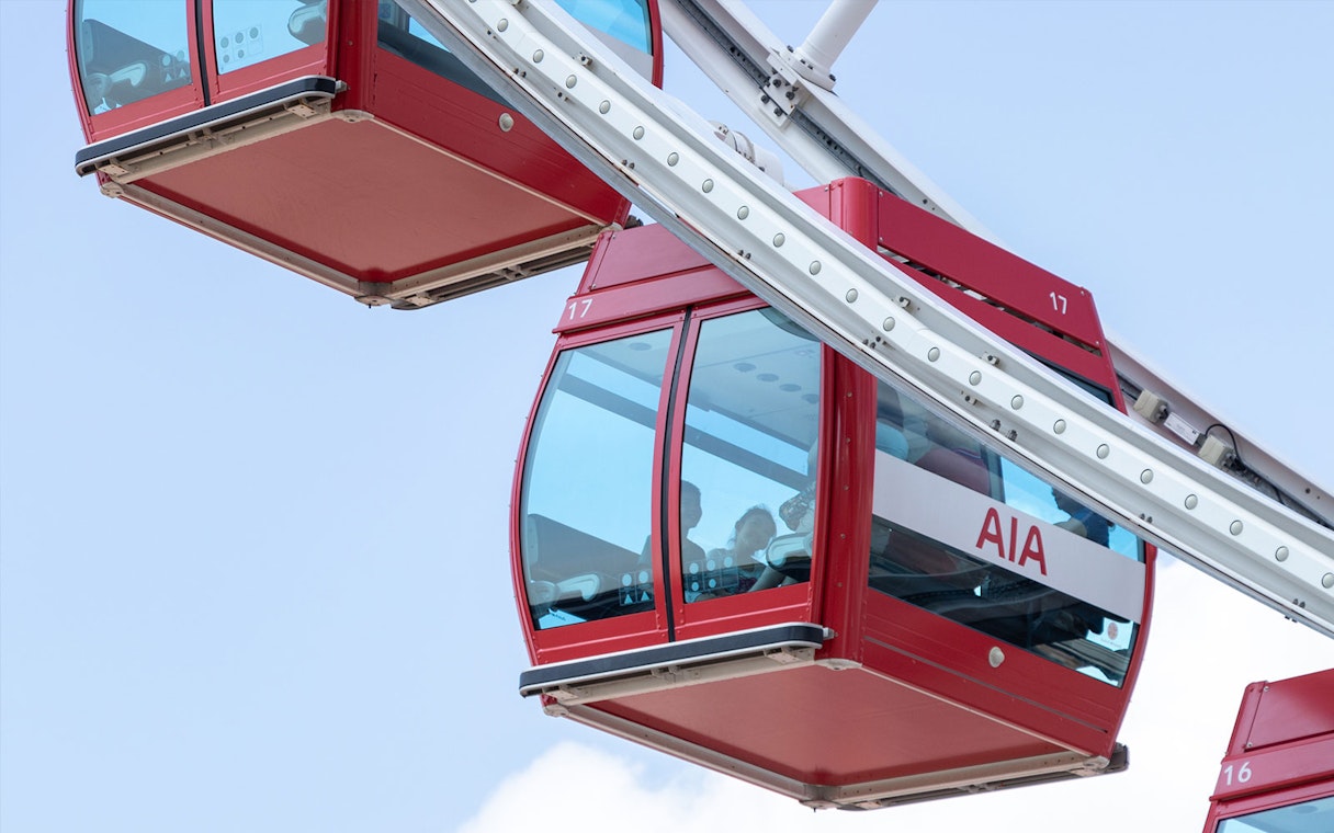 Red gondolas on the Hong Kong Observation Wheel against a clear sky.