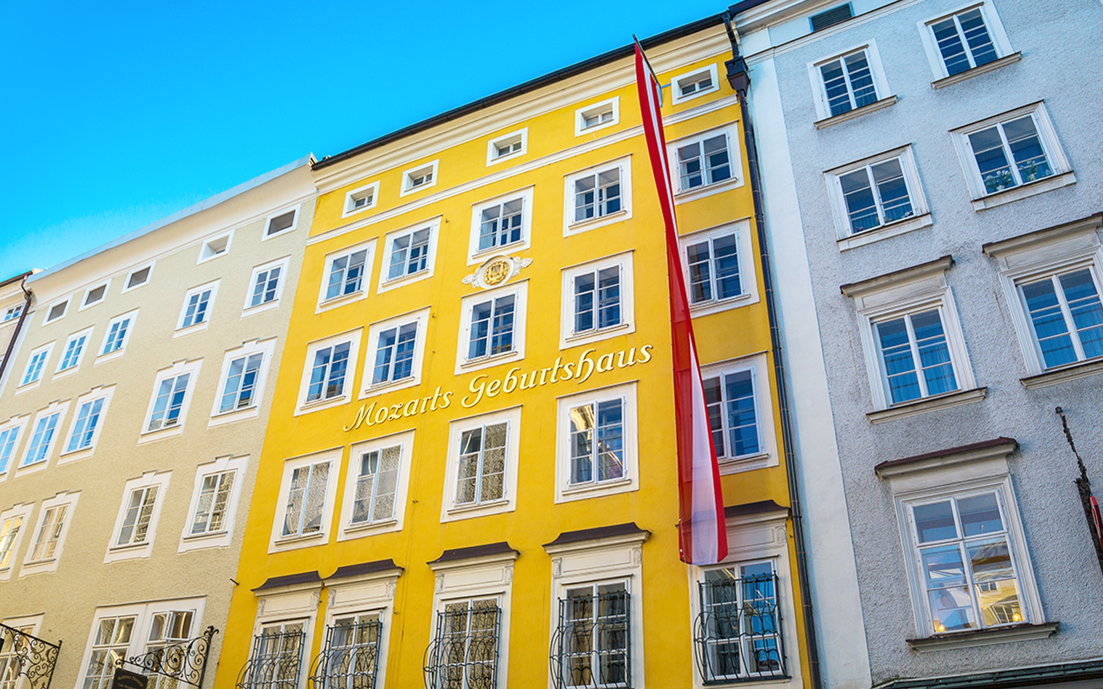 Mozart's birthplace in Salzburg, yellow building with red flag.