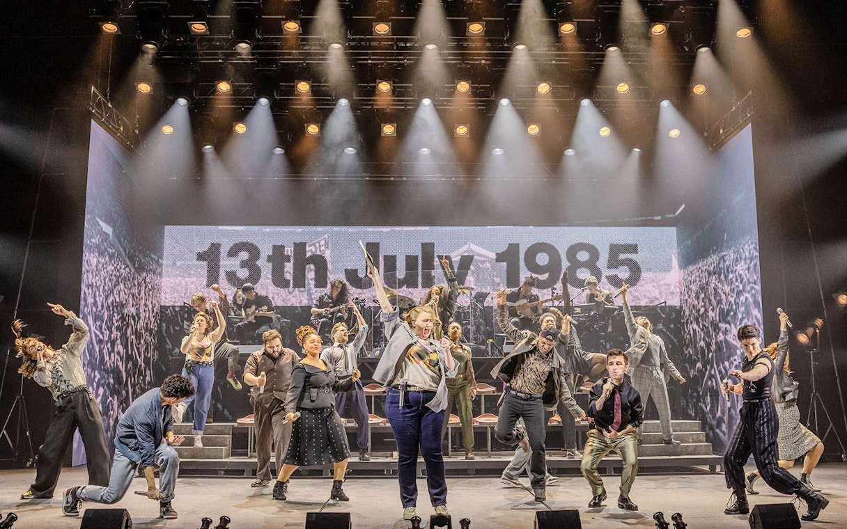Performers on stage at Just for One Day show, backdrop reads "13th July 1985".