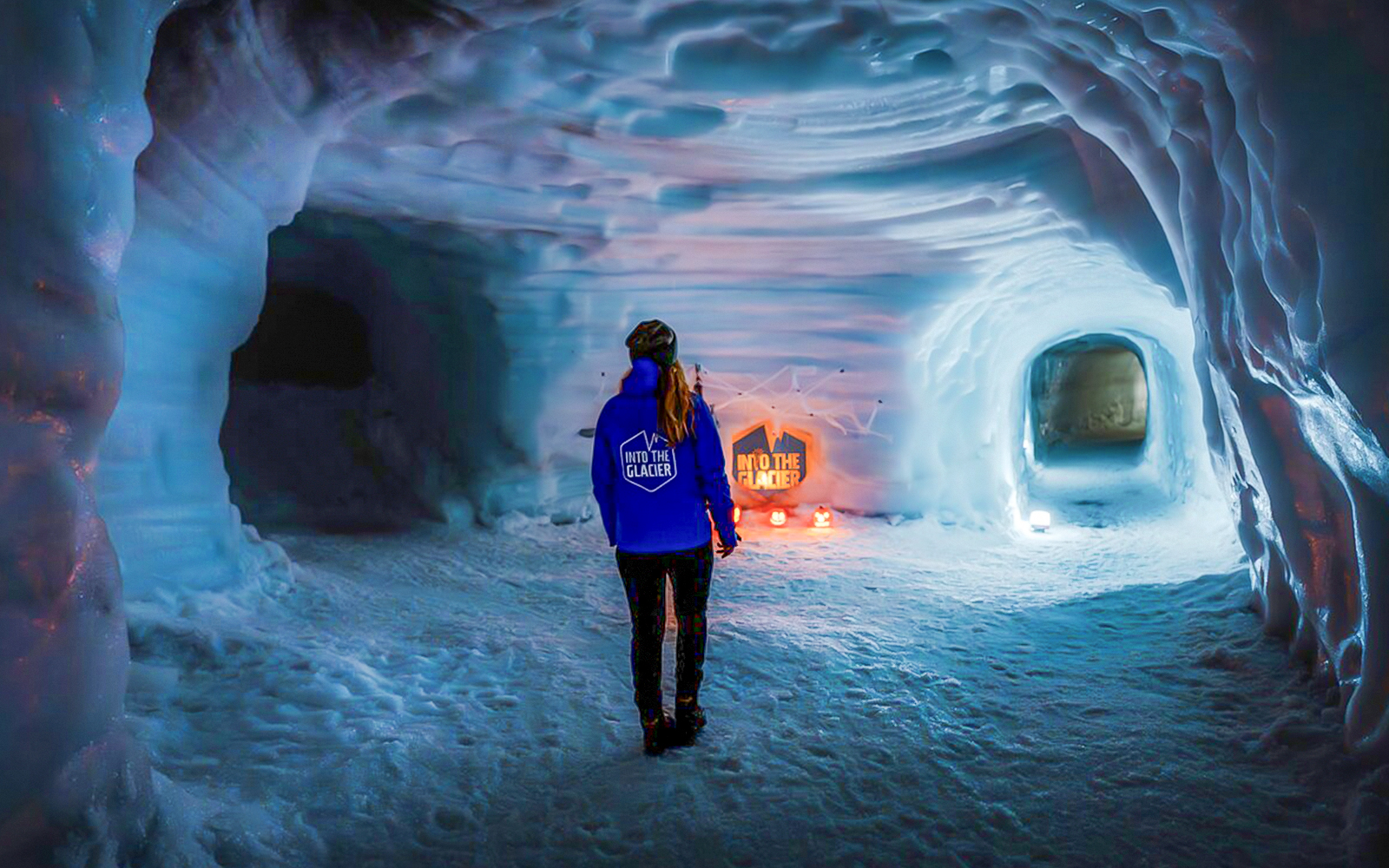 Guests walking inside the illuminated Ice Tunnel in Langjökull Glacier, Iceland.