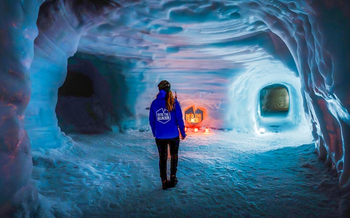 Guests walking inside the illuminated Ice Tunnel in Langjökull Glacier, Iceland.