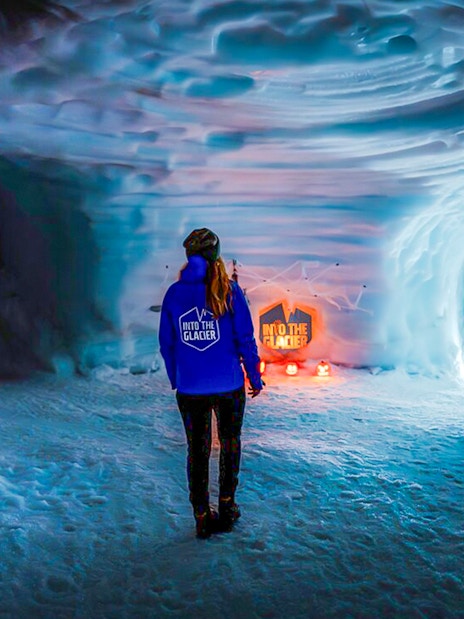 Guests walking inside the illuminated Ice Tunnel in Langjökull Glacier, Iceland.