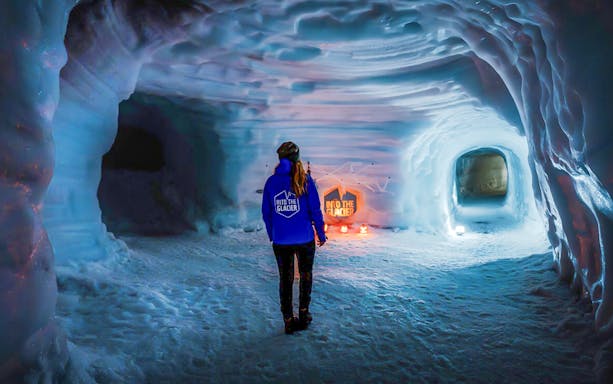 Guests walking inside the illuminated Ice Tunnel in Langjökull Glacier, Iceland.