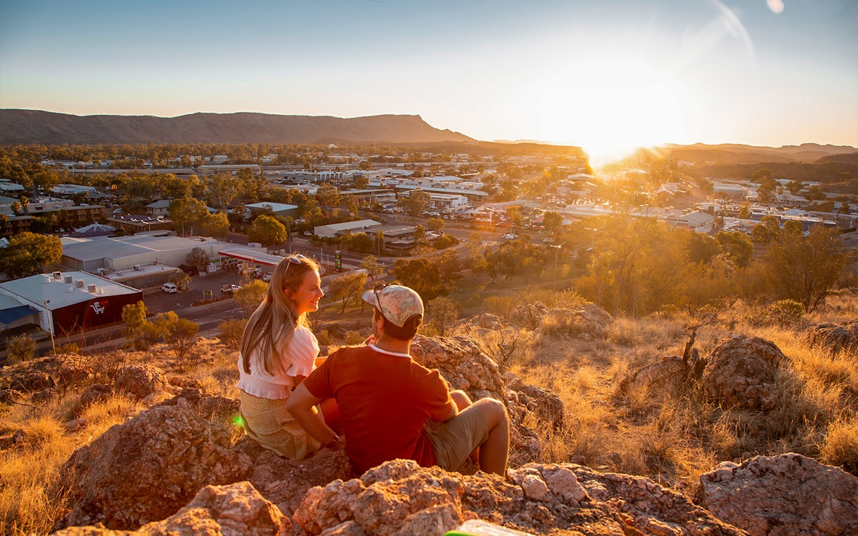 Couple enjoying sunset view over Alice Springs during half-day guided tour.