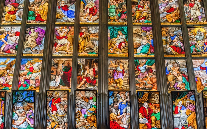 Stained glass windows depicting biblical scenes in Milan Duomo, Italy.