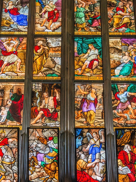 Stained glass windows depicting biblical scenes in Milan Duomo, Italy.