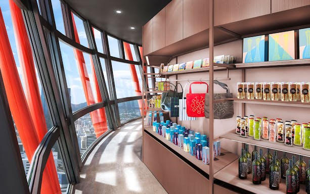 Gift shop inside Kobe Port Tower with city view through curved windows.
