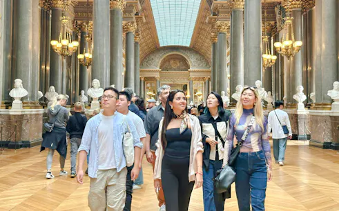 Visitors exploring the Hall of Mirrors on a Versailles guided tour.