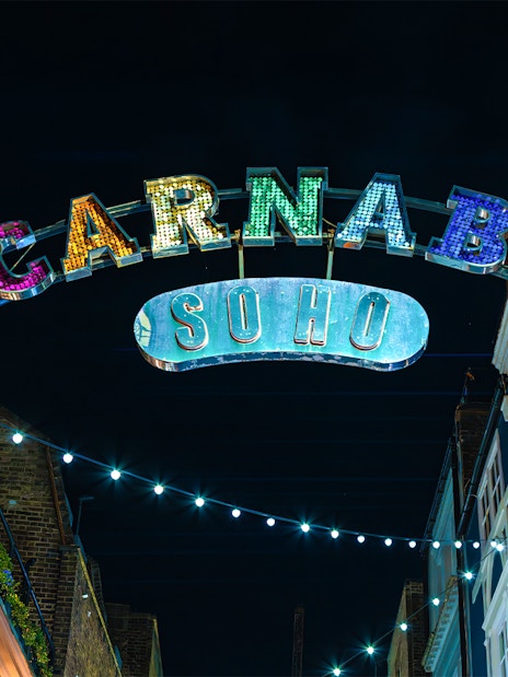 Carnaby Street sign illuminated at night in Soho, London.