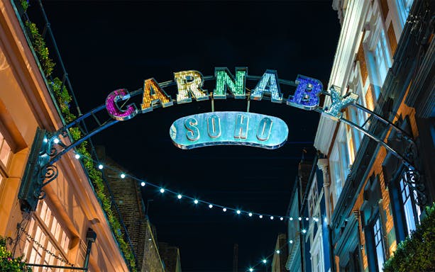 Carnaby Street sign illuminated at night in Soho, London.