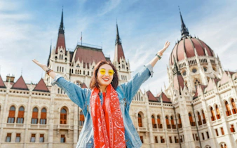 Visitor in front of Hungarian Parliament Building, Budapest, on St. Stephen Basilica Old Town Tour.