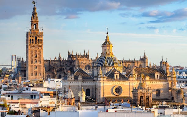 Seville Cathedral exterior with Gothic architecture and Giralda tower in Seville, Spain.