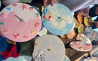 Seashell-decorated clocks being crafted during a coastal art workshop in Hanoi.