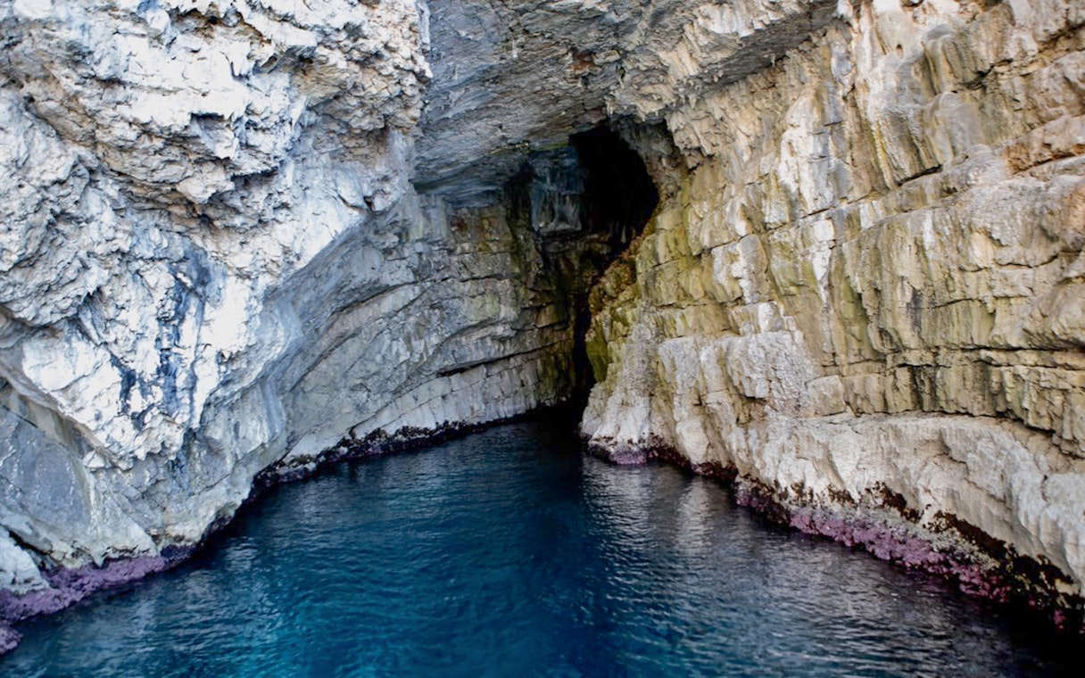 Blue Cave entrance with rocky walls and clear water in Kotor, Montenegro.