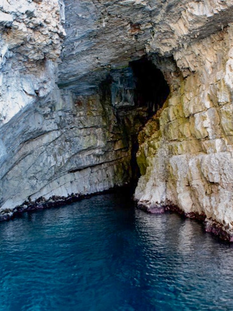 Blue Cave entrance with rocky walls and clear water in Kotor, Montenegro.
