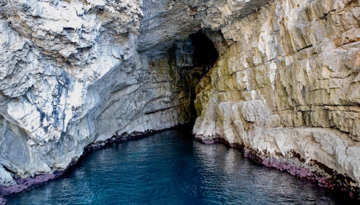 Blue Cave in Kotor with clear turquoise waters and rocky cave entrance.