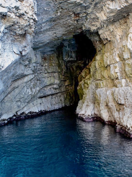 Blue Cave entrance with rocky walls and clear water in Kotor, Montenegro.