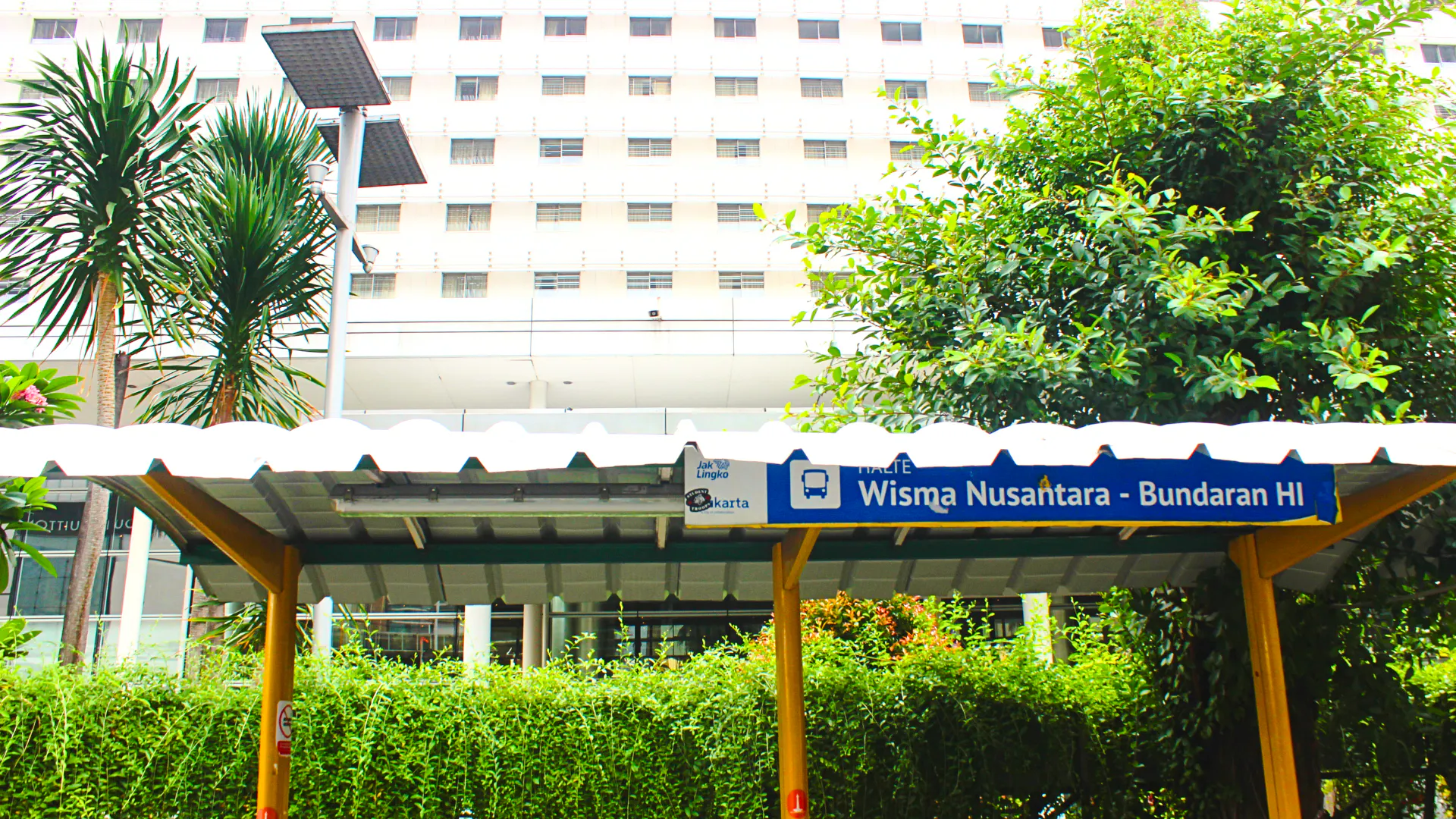 Wisma Nusantara MRT station sign in Jakarta, surrounded by greenery.